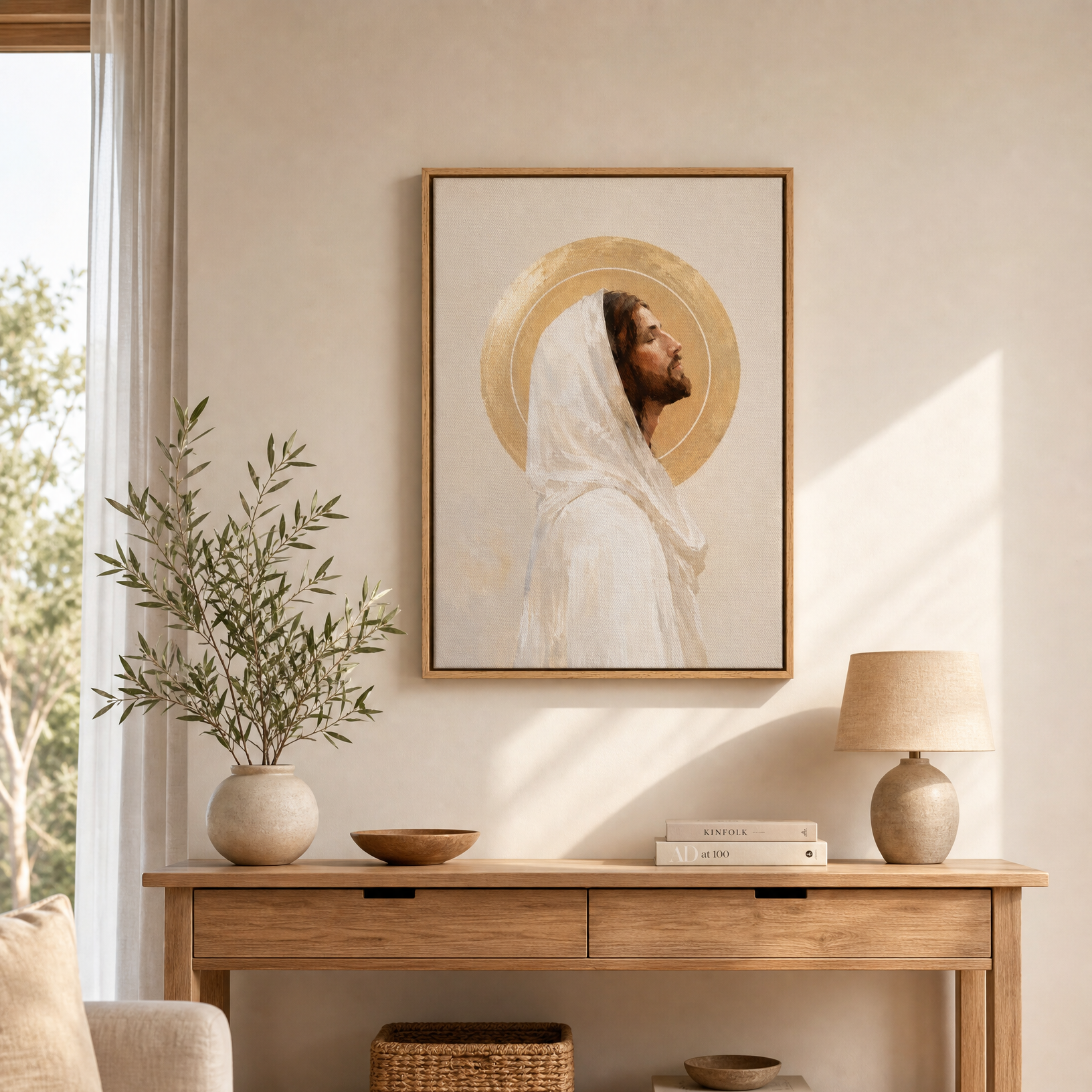 A framed art print of Jesus Christ with a gold halo, displayed on a beige wall above a wooden console table in a styled room setting.