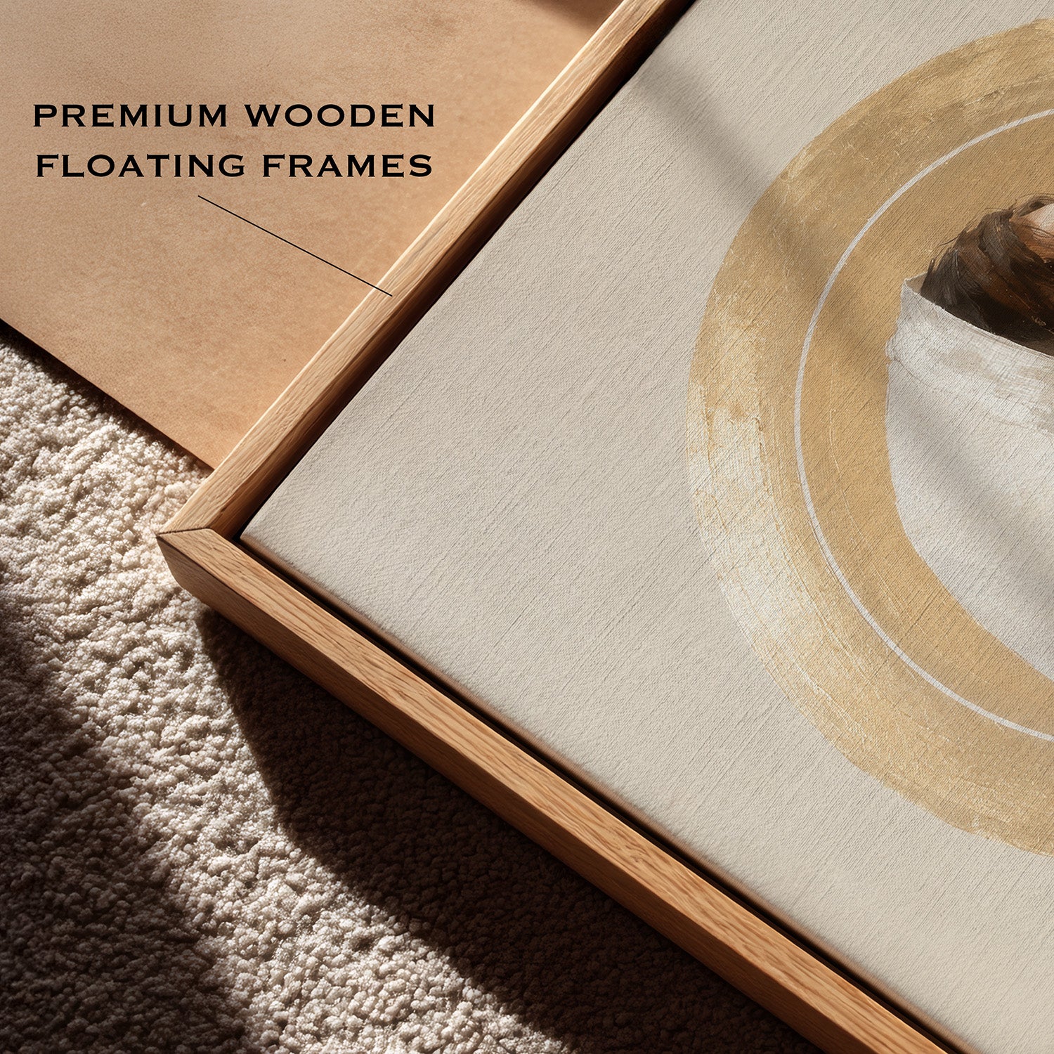 Close-up of a floating wooden frame with a cream canvas print featuring a gold circular brushstroke design, placed on a textured beige carpet. A second kraft-paper backing is visible, and the text 'PREMIUM WOODEN FLOATING FRAMES' appears in the upper left.