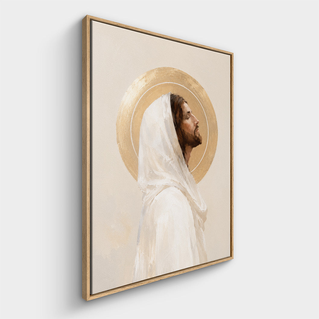 Framed wall art featuring a portrait of Jesus Christ with a white veil and a gold halo, shown hanging against a light gray wall.
